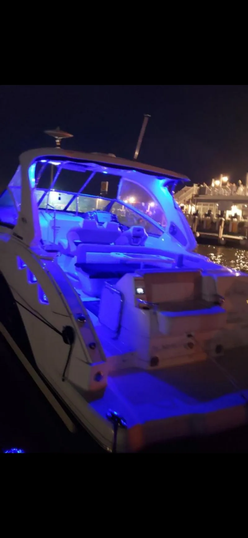 Slide: The Image of 2014 Chaparral 330 Signature Cruiser with blue LED lights at night docked in marina. - 2