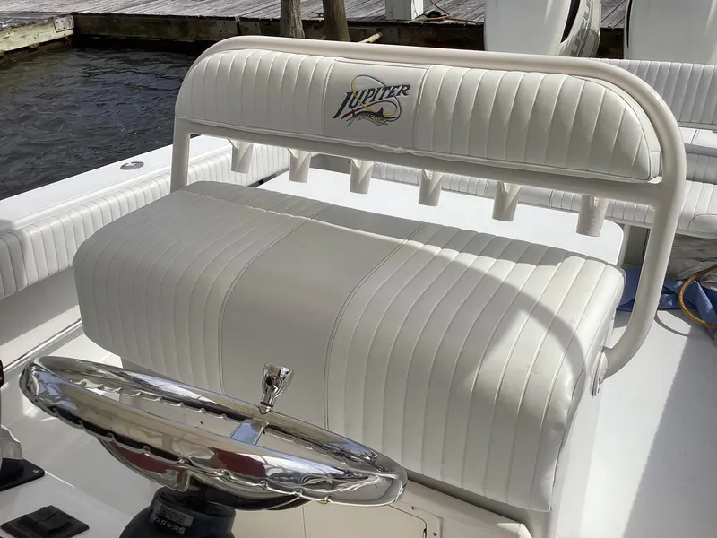 Slide: The Image of White cushioned seating on 2002 Jupiter 31 Cuddy boat with rod holders. - 11