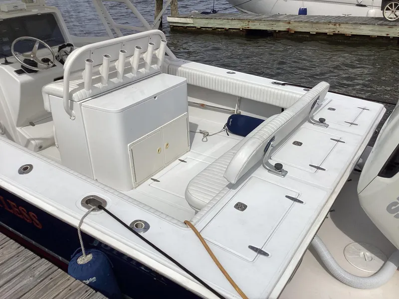 Slide: The Image of 2002 Jupiter 31 Cuddy boat with spacious deck and seating, docked by the water. - 4