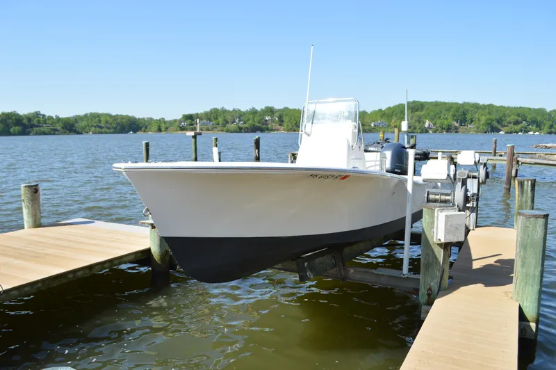 Slide: The Image of 2016 Layton Bay 22 boat docked on a sunny lake with lush green surroundings. - 10