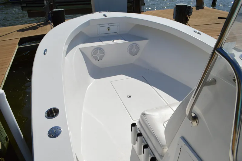 Slide: The Image of 2016 Layton Bay 22 boat interior with seating and storage, docked by the water. - 14