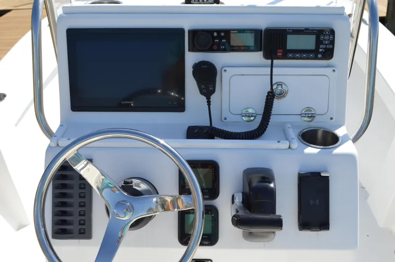 Slide: The Image of Control panel of a 2016 Layton Bay 22 boat with steering wheel and navigation equipment. - 22