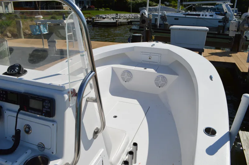 Slide: The Image of 2016 Layton Bay 22 boat interior with console and seating, docked by the water. - 23
