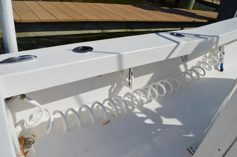 Slide: The Image of 2016 Layton Bay 22 boat deck with coiled hose and rod holders. - 30