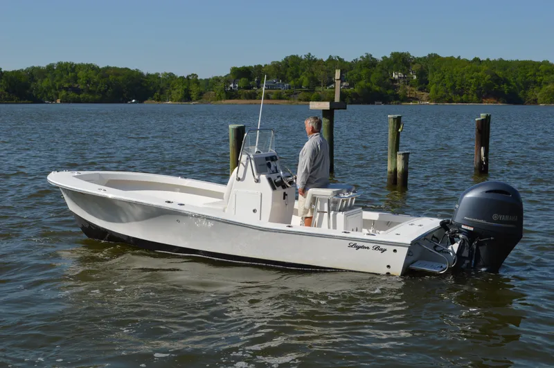 Slide: The Image of 2016 Layton Bay 22 boat on calm water with a person at the helm. - 4