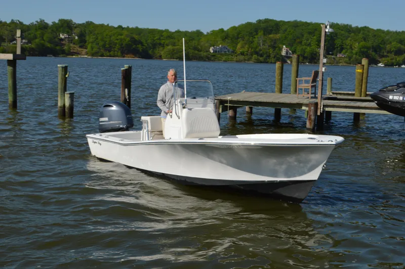Slide: The Image of 2016 Layton Bay 22 boat on water near dock, with person steering. - 9