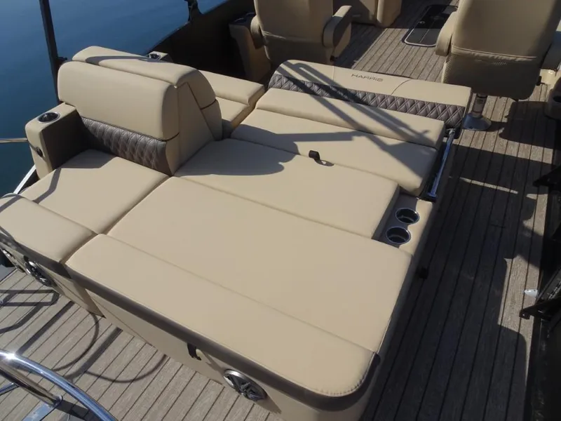 Slide: The Image of 2025 Harris Sunliner 250 boat with beige seating and cup holders on a wooden deck. - 11