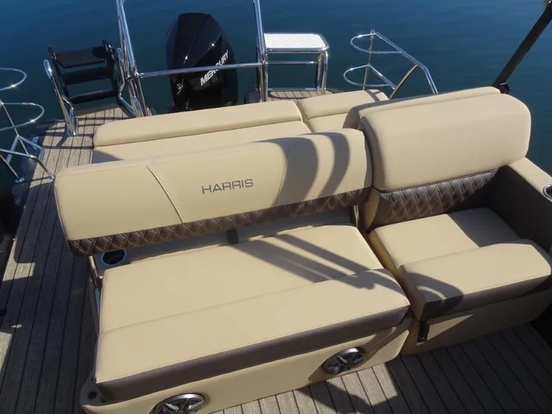 Slide: The Image of 2025 Harris Sunliner 250 boat with beige seating and Mercury outboard motor. - 12