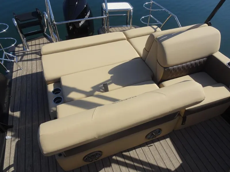 Slide: The Image of 2025 Harris Sunliner 250 boat with beige seating and cup holders on deck. - 13