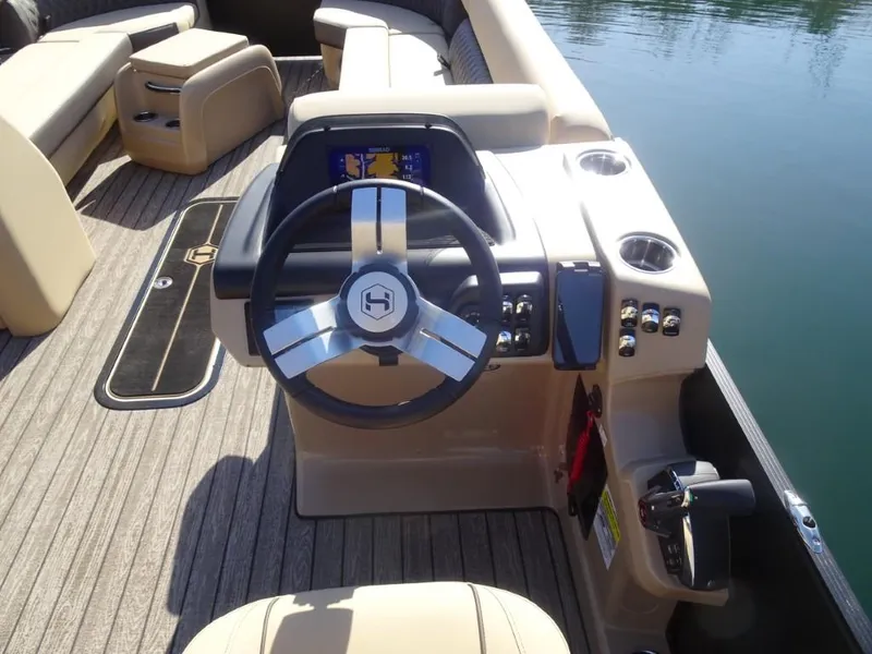 Slide: The Image of 2025 Harris Sunliner 250 boat interior with steering wheel and dashboard controls. - 16