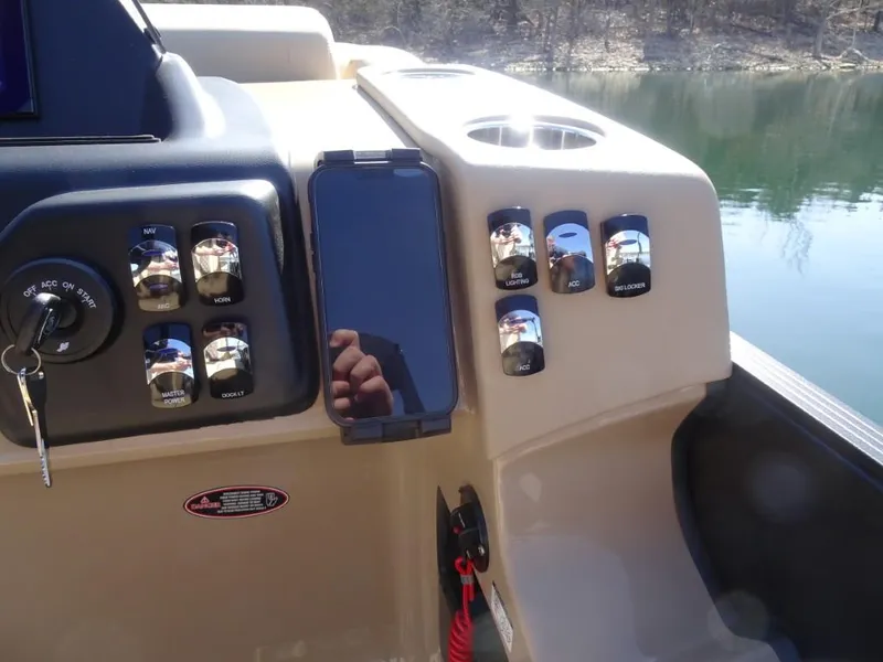 Slide: The Image of Control panel of 2025 Harris Sunliner 250 boat with switches and smartphone holder. - 19