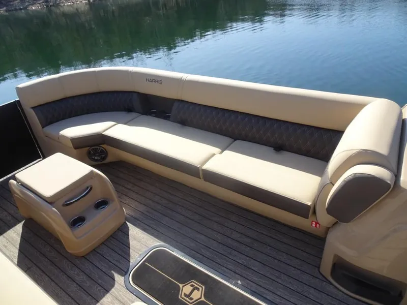 Slide: The Image of 2025 Harris Sunliner 250 boat interior with beige seating and wood flooring. - 23