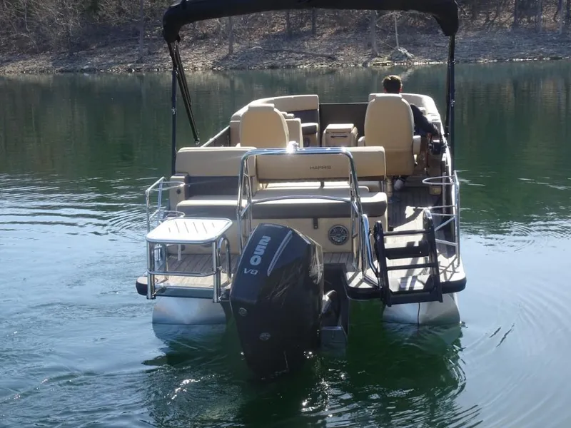 Slide: The Image of 2025 Harris Sunliner 250 pontoon boat on a calm lake, rear view. - 3