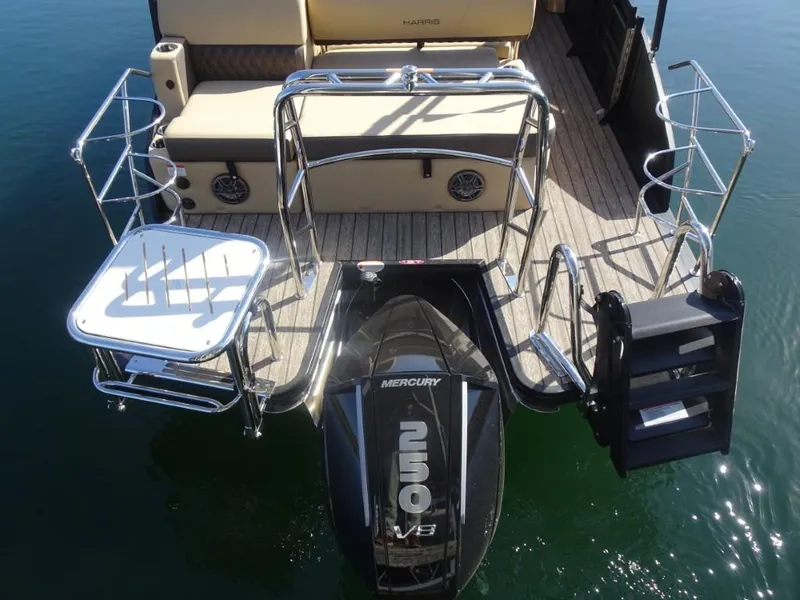 Slide: The Image of 2025 Harris Sunliner 250 boat with Mercury engine, rear view showing seating and swim platform. - 6
