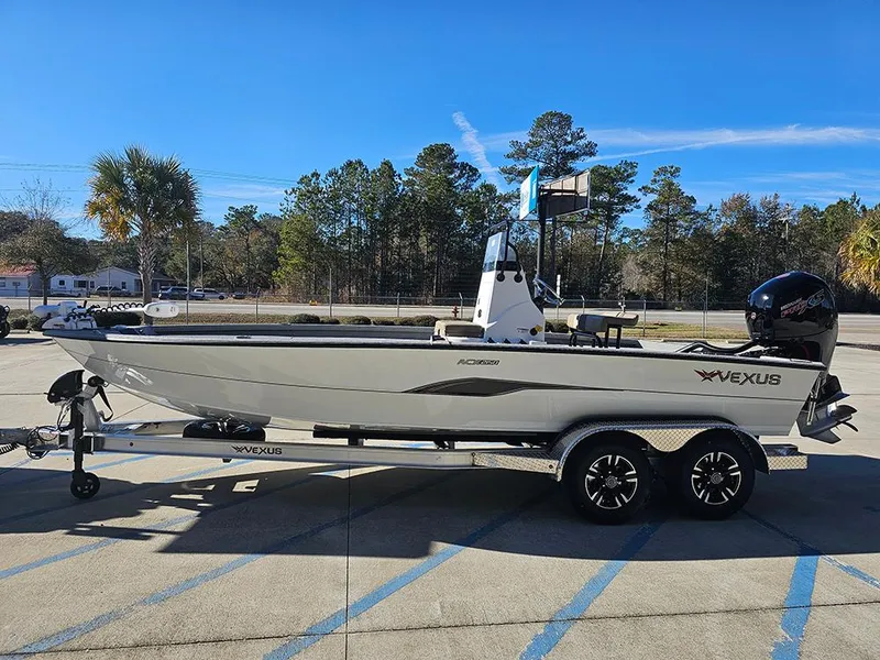 Slide: The Image of 2025 Vexus ACX2150 boat on trailer, parked outdoors with trees in background. - 6