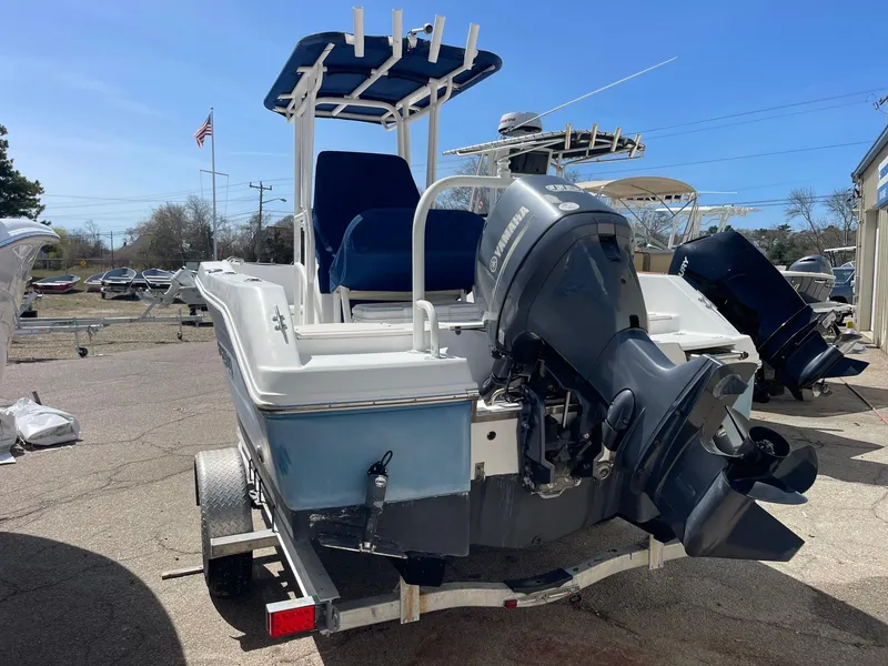 Slide: The Image of 2012 Robalo 180 CC boat on trailer with outboard motor, parked outdoors. - 1