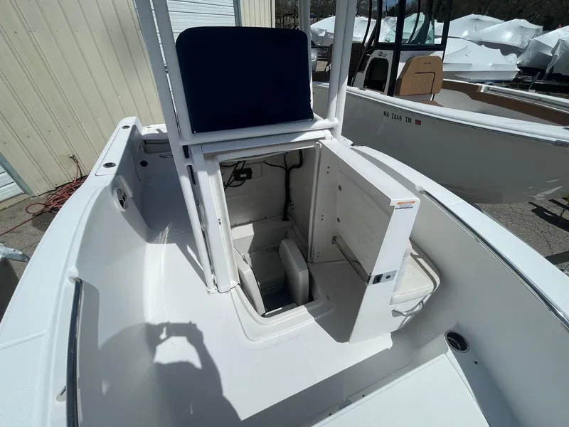 Slide: The Image of 2012 Robalo 180 CC boat interior with open storage compartment, white deck, and blue seat. - 14