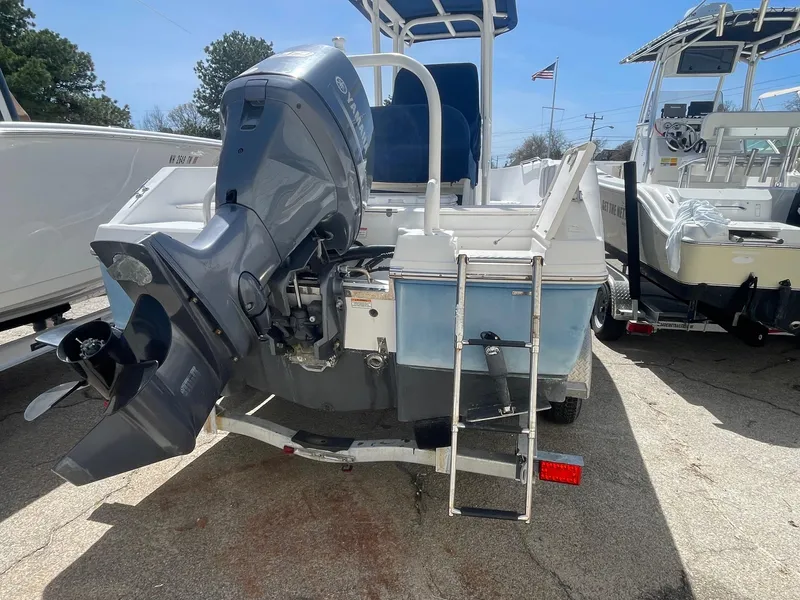 Slide: The Image of 2012 Robalo 180 CC boat with outboard motor and ladder, parked on a trailer. - 2