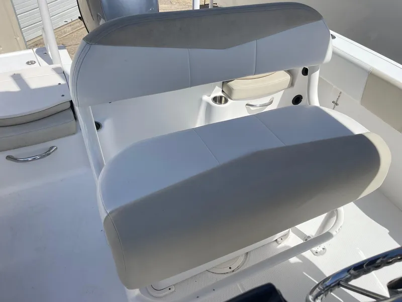 Slide: The Image of 2012 Robalo 180 CC boat seating, featuring white and gray cushioned seats. - 8