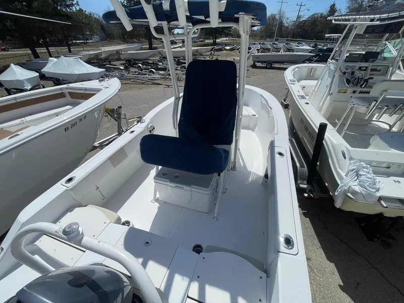 Slide: The Image of 2012 Robalo 180 CC boat with blue seating, docked among other boats. - 9