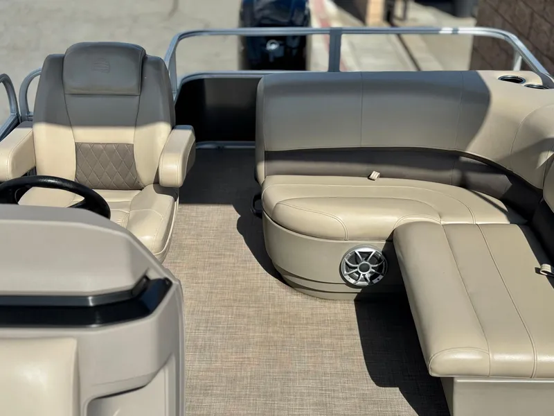 Slide: The Image of 2024 Sun Tracker Party Barge 18 DLX interior with beige seating and speaker system. - 11