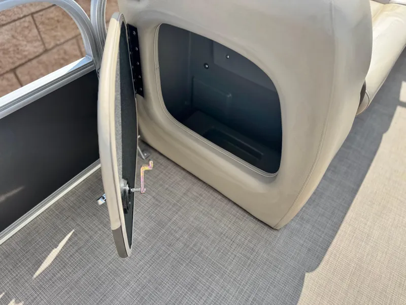 Slide: The Image of 2024 Sun Tracker Party Barge 18 DLX storage compartment with open door, beige interior. - 14