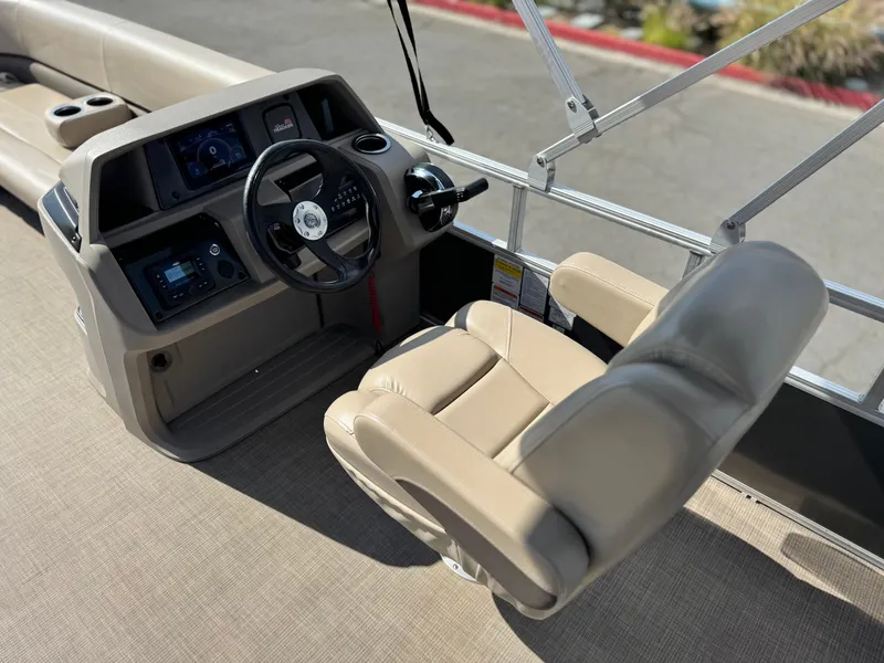 Slide: The Image of 2024 Sun Tracker Party Barge 18 DLX helm with beige captain's chair and steering console. - 17