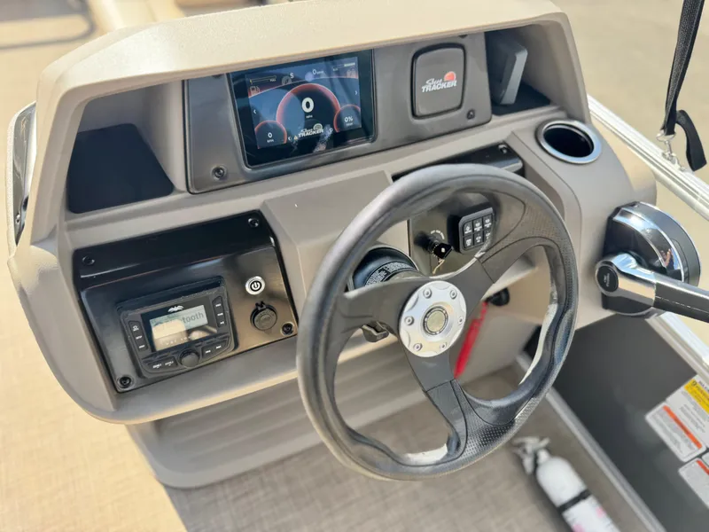 Slide: The Image of 2024 Sun Tracker Party Barge 18 DLX dashboard with steering wheel and control panel. - 19