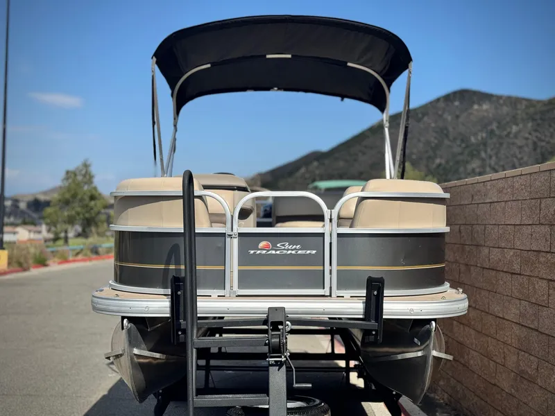 Slide: The Image of 2024 Sun Tracker Party Barge 18 DLX pontoon boat with canopy, parked on trailer. - 2