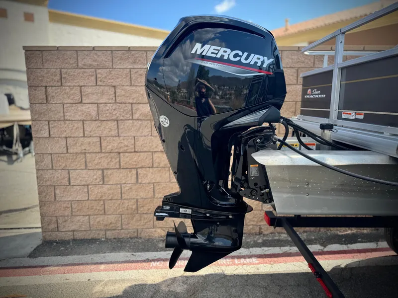 Slide: The Image of 2024 Sun Tracker Party Barge 18 DLX with Mercury outboard motor, parked outdoors. - 6