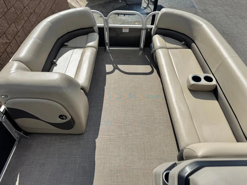 Slide: The Image of 2024 Sun Tracker Party Barge 18 DLX interior with beige seating and cup holders. - 8