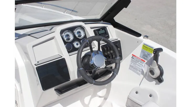 Slide: The Image of 2025 Starcraft SVX 210 OB DC boat dashboard with steering wheel and control panel. - 12