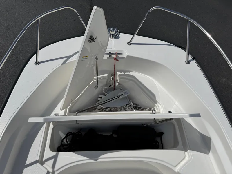 Slide: The Image of 2022 Boston Whaler 170 Montauk boat anchor storage compartment open, showing anchor and ropes. - 6