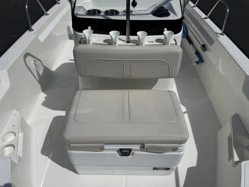 Slide: The Image of 2022 Boston Whaler 170 Montauk boat interior with cushioned seating and rod holders. - 7