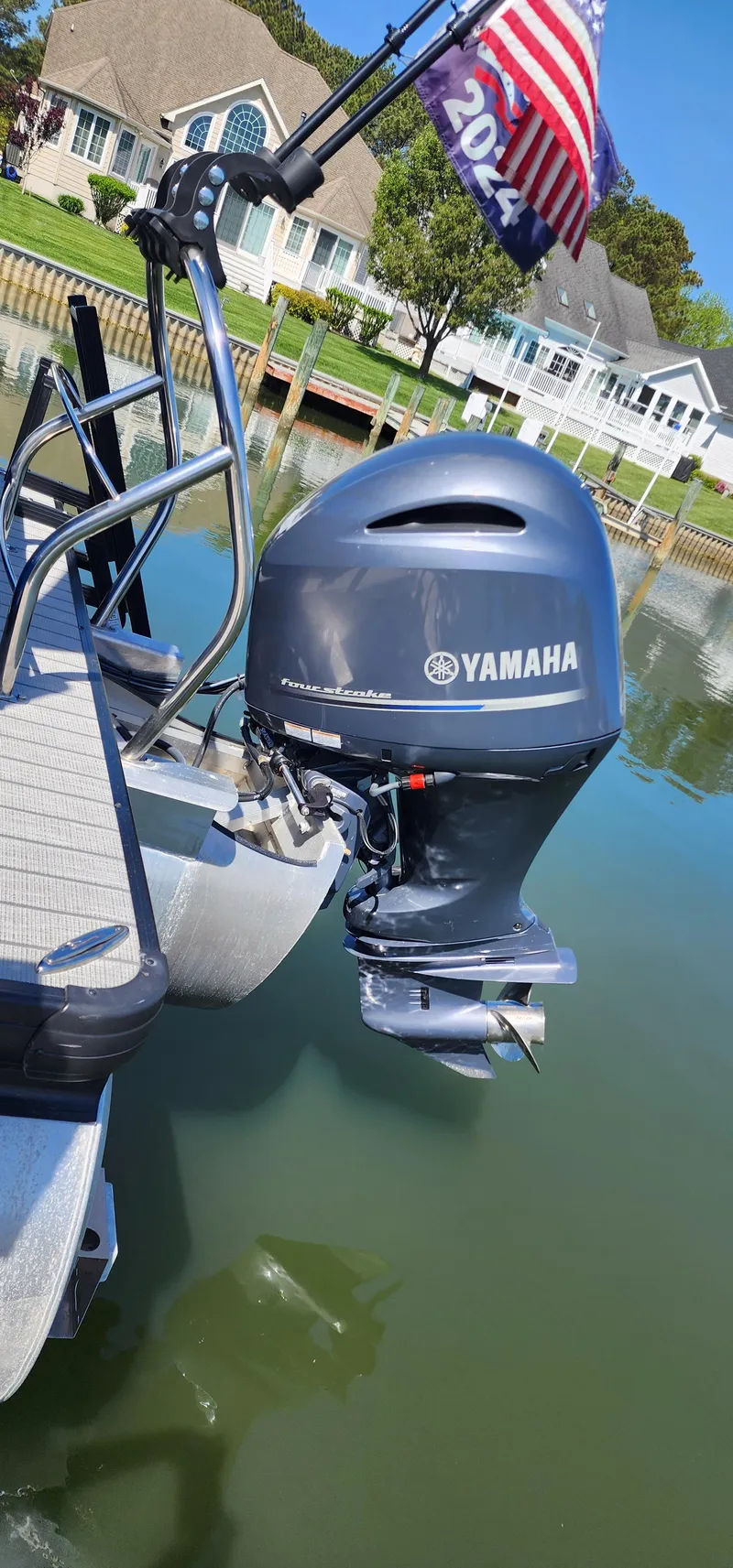 Slide: The Image of 2023 Godfrey SWEETWATER 2286 SB with Yamaha outboard motor on a calm lake. - 2