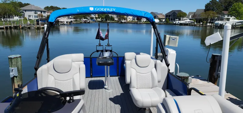 Slide: The Image of 2023 Godfrey SWEETWATER 2286 SB pontoon boat docked on a serene lake. - 7