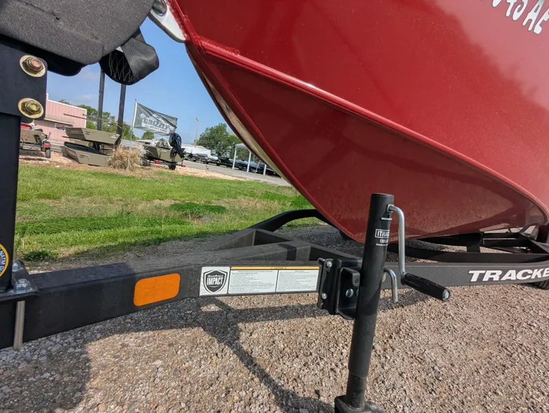 Slide: The Image of 2024 Tracker Super Guide V-16 SC boat on trailer, parked on gravel. - 10