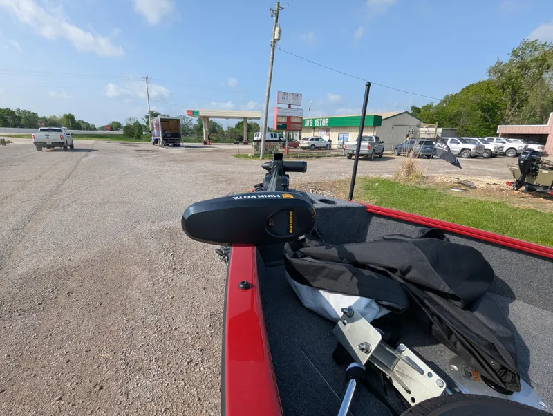 Slide: The Image of 2024 Tracker Super Guide V-16 SC boat parked near a rural gas station. - 13