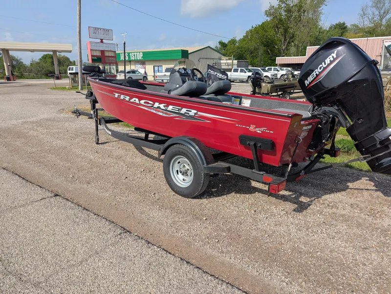 Slide: The Image of 2024 Tracker Super Guide V-16 SC boat on trailer, red exterior, parked outdoors. - 2