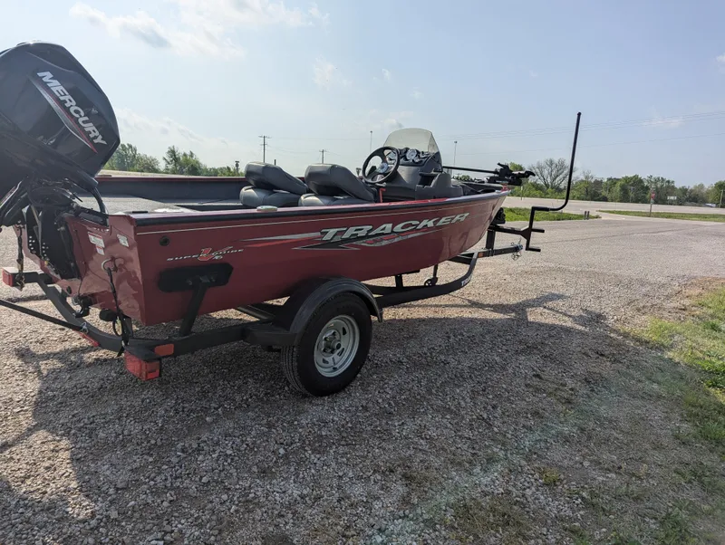 Slide: The Image of 2024 Tracker Super Guide V-16 SC boat on trailer, parked on gravel. - 6