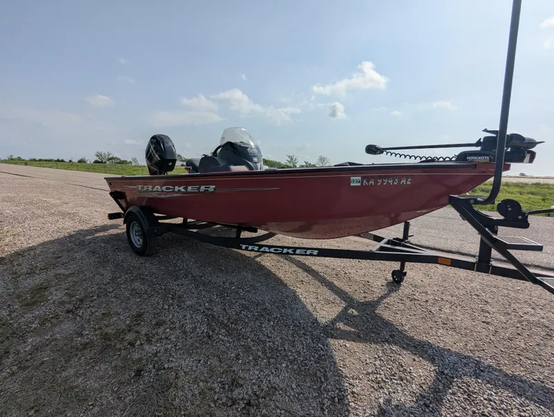 Slide: The Image of 2024 Tracker Super Guide V-16 SC boat on trailer, parked on gravel road. - 8