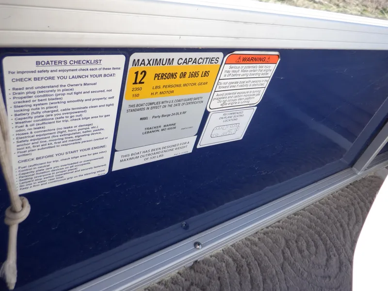 Slide: The Image of 2014 Sun Tracker Party Barge 24 DLX capacity label, showing 12-person or 1,685 lbs limit. - 19