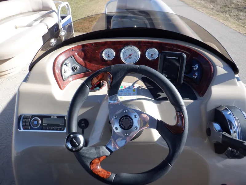 Slide: The Image of 2014 Sun Tracker Party Barge 24 DLX dashboard with steering wheel and controls. - 25