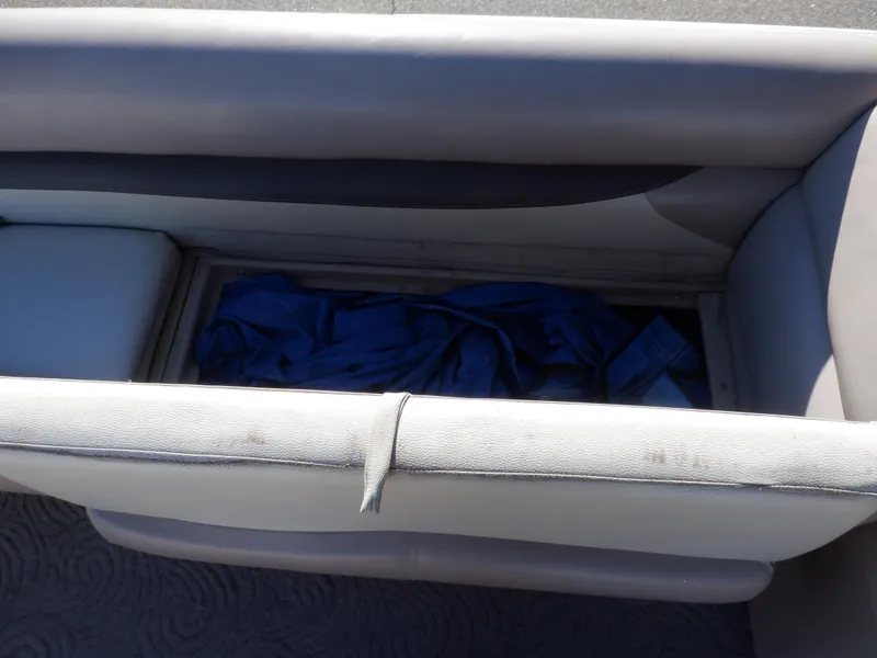 Slide: The Image of 2014 Sun Tracker Party Barge 24 DLX storage compartment with blue cover inside. - 27