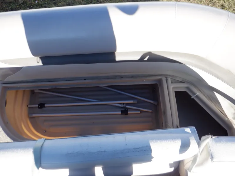 Slide: The Image of 2014 Sun Tracker Party Barge 24 DLX storage compartment with metal poles inside. - 32