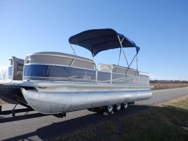 Slide: The Image of 2014 Sun Tracker Party Barge 24 DLX pontoon boat with blue canopy on a trailer. - 8