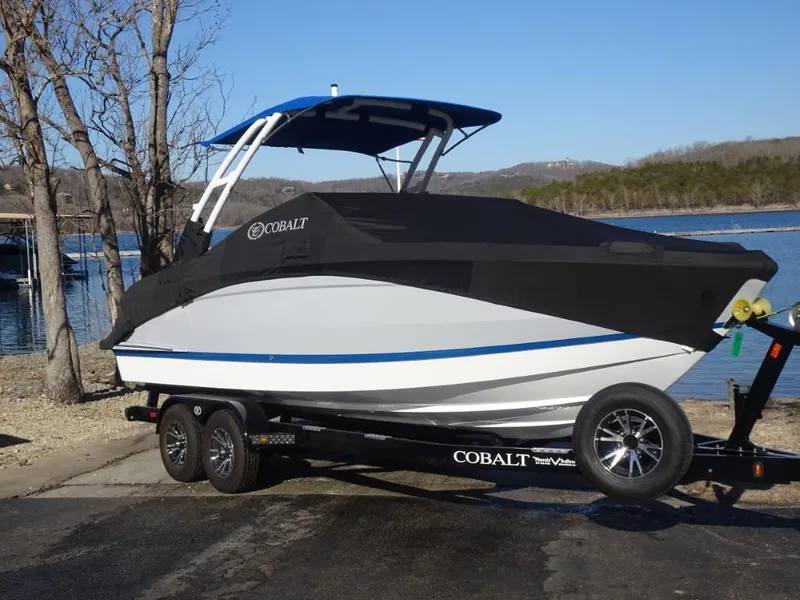 Slide: The Image of 2025 Cobalt R4 boat on trailer by a lake, covered and ready for transport. - 26