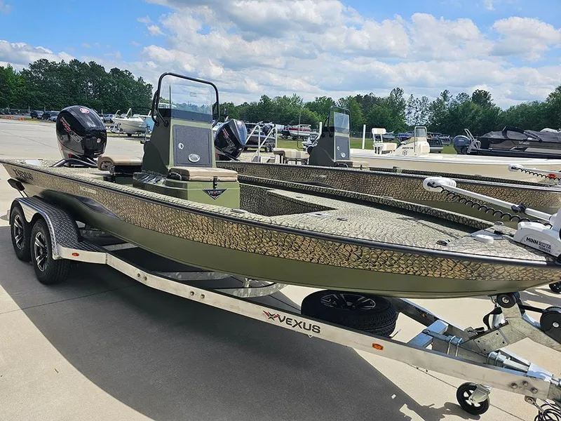 Slide: The Image of 2025 Vexus ACX 2000 boat on trailer, featuring dual motors and camouflage design. - 2