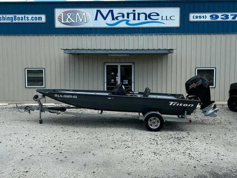 Slide: The Image of 2019 Triton 18 TX boat on trailer outside L&M Marine LLC building. - 0