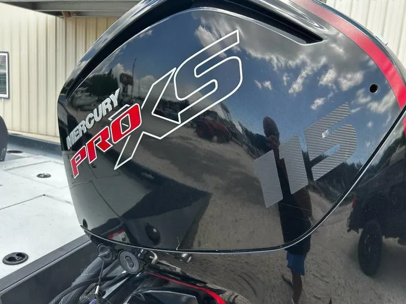 Slide: The Image of Mercury Pro XS 115 engine on 2019 Triton 18 TX boat, reflecting sky and surroundings. - 10